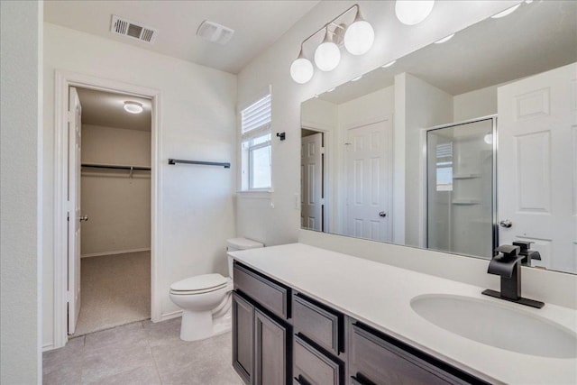 186 Sundown Ave, Buda, TX 78610 - bathroom with a shower stall, vanity, a spacious closet, tile patterned flooring, and toilet