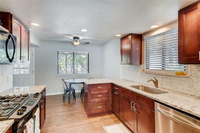 9214 Independence Loop, Austin, TX 78748 - kitchen with appliances with stainless steel finishes, light wood finished floors, backsplash, a ceiling fan, and recessed lighting