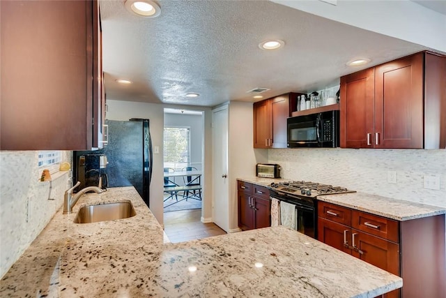 9214 Independence Loop, Austin, TX 78748 - kitchen featuring black appliances, backsplash, light stone counters, recessed lighting, and a textured ceiling