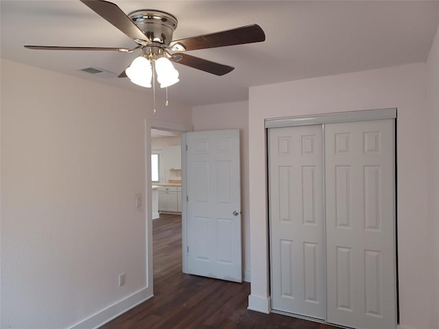 23393 Nameless Rd Unit 164, Leander, TX 78641 - unfurnished bedroom with baseboards, dark wood-type flooring, a closet, and a ceiling fan