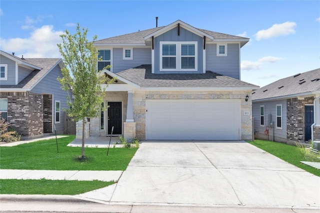 113 Bent Creek Ln, Georgetown, TX 78628 - view of front of house with stone siding, concrete driveway, a front lawn, a garage, and board and batten siding