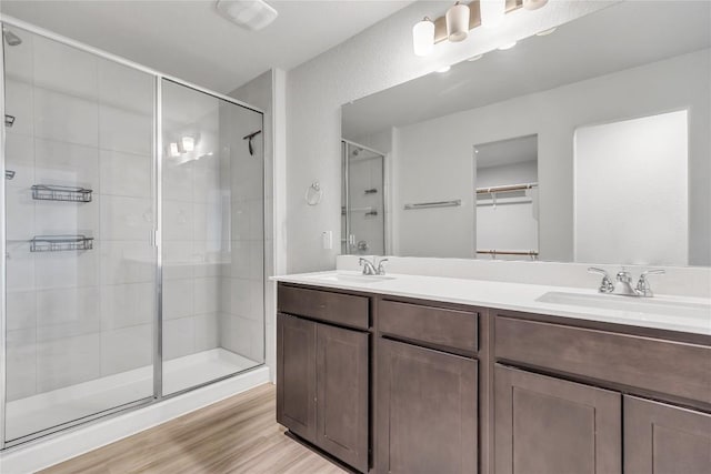 113 Bent Creek Ln, Georgetown, TX 78628 - bathroom featuring a stall shower, double vanity, wood finished floors, and a walk in closet