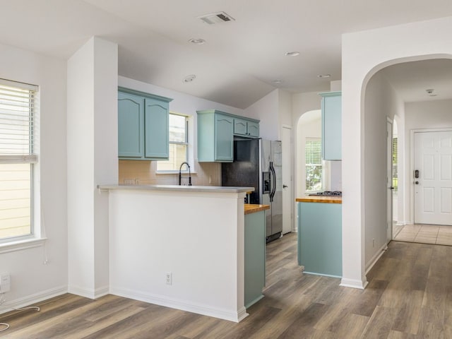 8425 Shallot Way, Austin, TX 78748 - kitchen featuring arched walkways, stainless steel fridge with ice dispenser, wood finished floors, a sink, and butcher block countertops