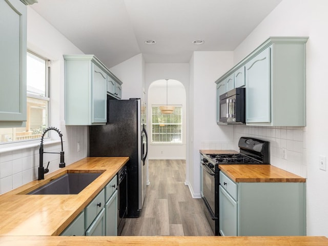 8425 Shallot Way, Austin, TX 78748 - kitchen featuring black gas range oven, wooden counters, a sink, light wood-type flooring, and healthy amount of natural light