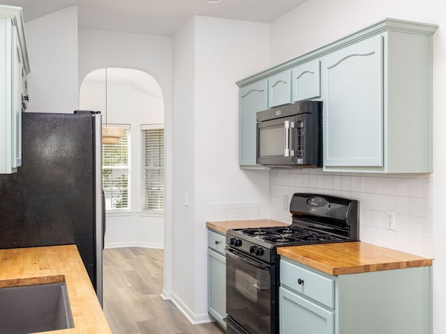 8425 Shallot Way, Austin, TX 78748 - kitchen featuring black appliances, butcher block countertops, light wood-style floors, and backsplash