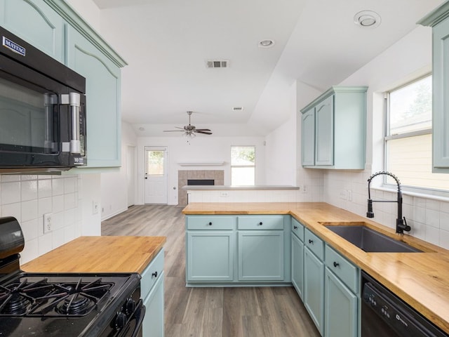 8425 Shallot Way, Austin, TX 78748 - kitchen with butcher block counters, black appliances, a sink, ceiling fan, and vaulted ceiling