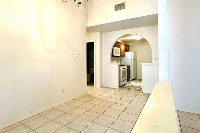 1121 Peggotty Pl, Austin, TX 78753 - unfurnished room with arched walkways, light tile patterned floors, and a high ceiling