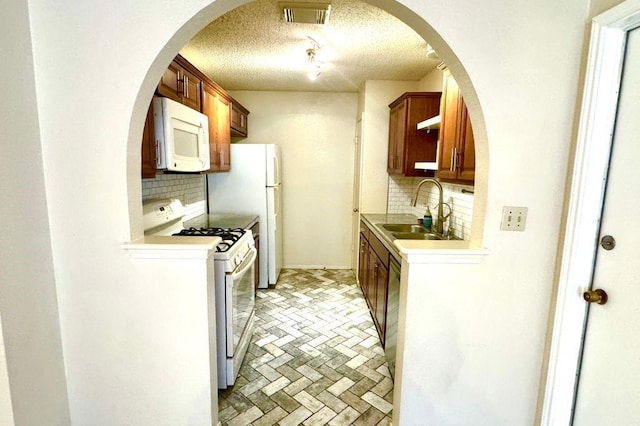 1121 Peggotty Pl, Austin, TX 78753 - kitchen with white appliances, backsplash, a textured ceiling, brick patterned flooring, and light countertops