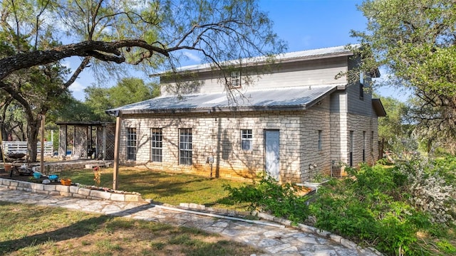 4414 Three Creek Trl, Spicewood, TX 78669 - rear view of house with metal roof and a lawn