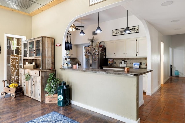 4414 Three Creek Trl, Spicewood, TX 78669 - kitchen with freestanding refrigerator, white cabinets, backsplash, a peninsula, and a towering ceiling