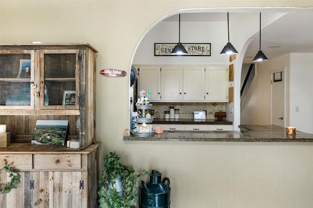 4414 Three Creek Trl, Spicewood, TX 78669 - kitchen featuring arched walkways, decorative backsplash, white cabinetry, and pendant lighting