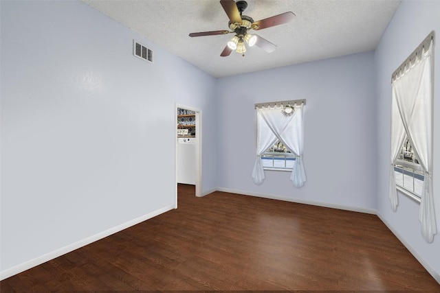 4414 Three Creek Trl, Spicewood, TX 78669 - spare room with a textured ceiling, dark wood-style flooring, baseboards, and a ceiling fan