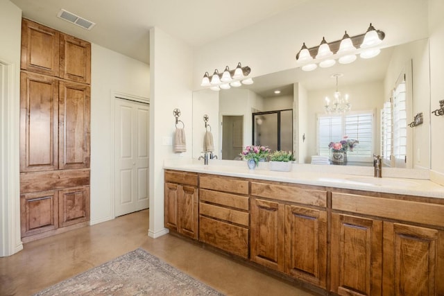 192 Indian Oaks Pass, Blanco, TX 78606 - bathroom featuring finished concrete floors, double vanity, a shower stall, and a chandelier