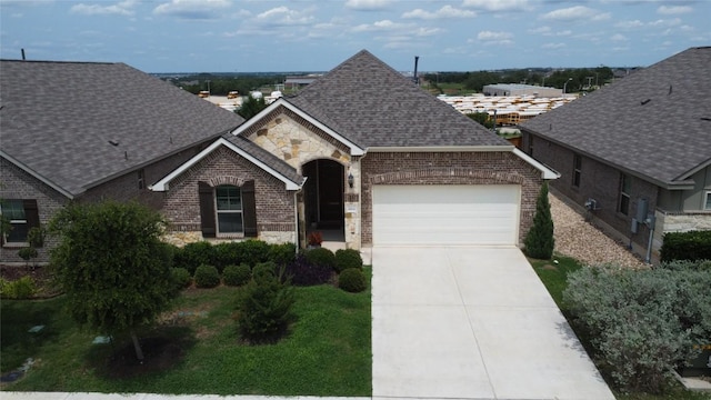 2212 Mcclendon Trl, Leander, TX 78641 - french provincial home with a garage, brick siding, a shingled roof, driveway, and stone siding