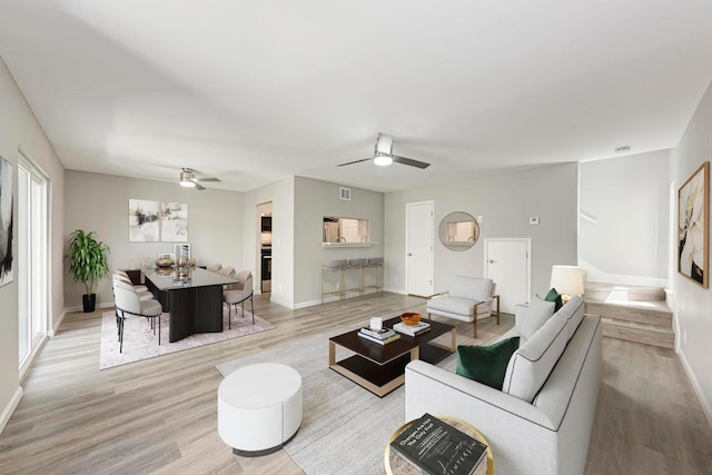 6718 Silvermine Dr Unit 804, Austin, TX 78736 - living room featuring a ceiling fan, light wood-style flooring, baseboards, and stairway