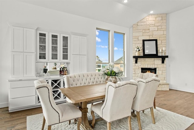 116 Egret Ln, Austin, TX 78737 - dining room featuring lofted ceiling, wood finished floors, a fireplace, and baseboards