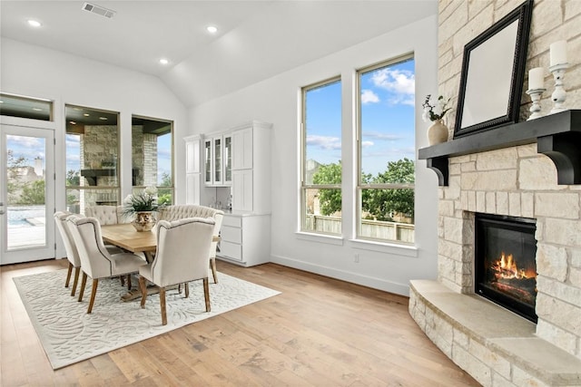 116 Egret Ln, Austin, TX 78737 - dining area with vaulted ceiling, healthy amount of natural light, a stone fireplace, light wood-style floors, and recessed lighting