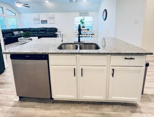 157 Monroe Dr, Kyle, TX 78640 - kitchen with dishwasher, a sink, light wood finished floors, ceiling fan, and light stone countertops