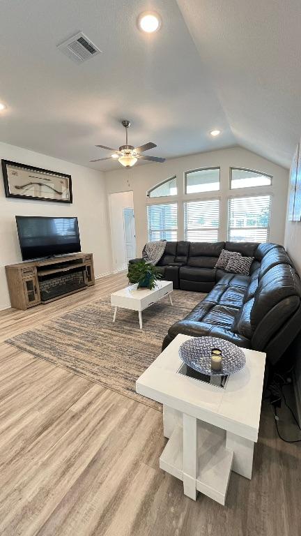 157 Monroe Dr, Kyle, TX 78640 - living area featuring wood finished floors, ceiling fan, vaulted ceiling, and recessed lighting