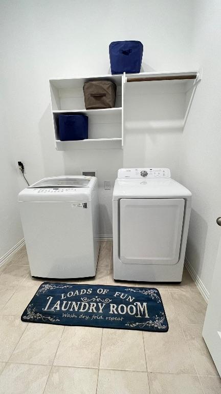 157 Monroe Dr, Kyle, TX 78640 - washroom with washer and dryer, tile patterned flooring, and baseboards