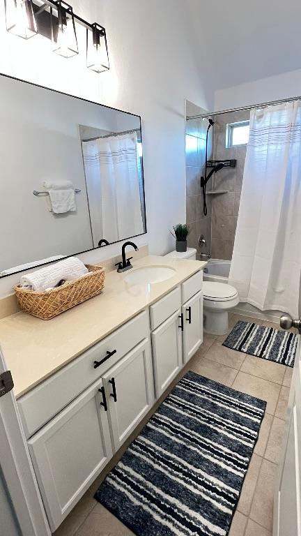 157 Monroe Dr, Kyle, TX 78640 - full bath with tile patterned floors, vanity, toilet, shower / bath combo with shower curtain, and vaulted ceiling