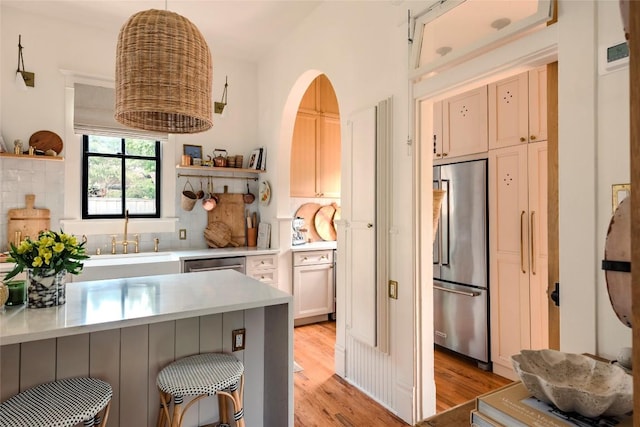 8608 Georgian Dr, Austin, TX 78753 - kitchen featuring appliances with stainless steel finishes, open shelves, a sink, light wood-style floors, and light countertops