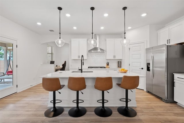 1305 Crescent Ln, Georgetown, TX 78633 - kitchen featuring stainless steel fridge, a sink, wall chimney range hood, a center island with sink, and decorative backsplash