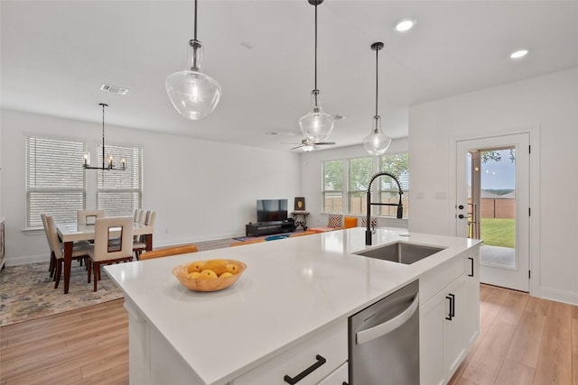 1305 Crescent Ln, Georgetown, TX 78633 - kitchen featuring stainless steel dishwasher, a sink, light wood finished floors, light countertops, and white cabinetry