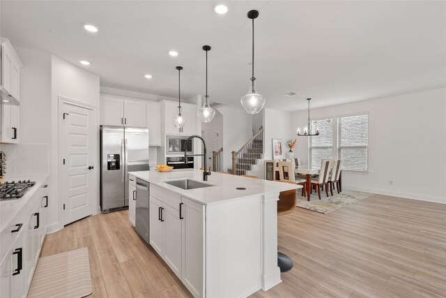 1305 Crescent Ln, Georgetown, TX 78633 - kitchen with appliances with stainless steel finishes, recessed lighting, light wood-style flooring, a kitchen island with sink, and light countertops