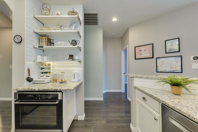 745 Bent Wood Pl, Round Rock, TX 78665 - kitchen with oven, dark wood-style floors, tasteful backsplash, baseboards, and light stone countertops