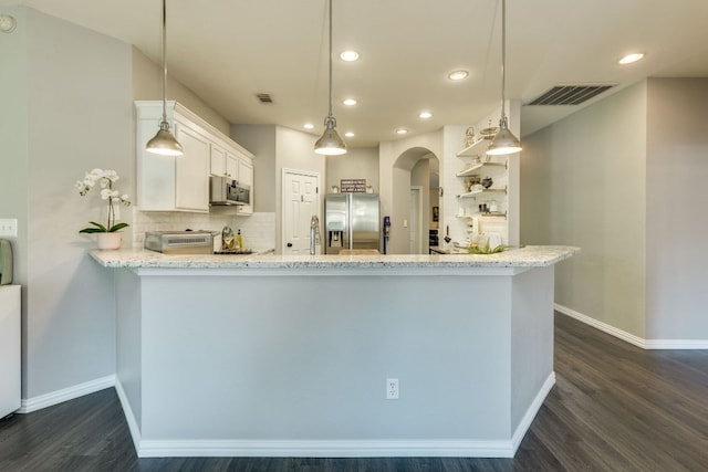 745 Bent Wood Pl, Round Rock, TX 78665 - kitchen with appliances with stainless steel finishes, arched walkways, recessed lighting, dark wood-style flooring, and decorative backsplash