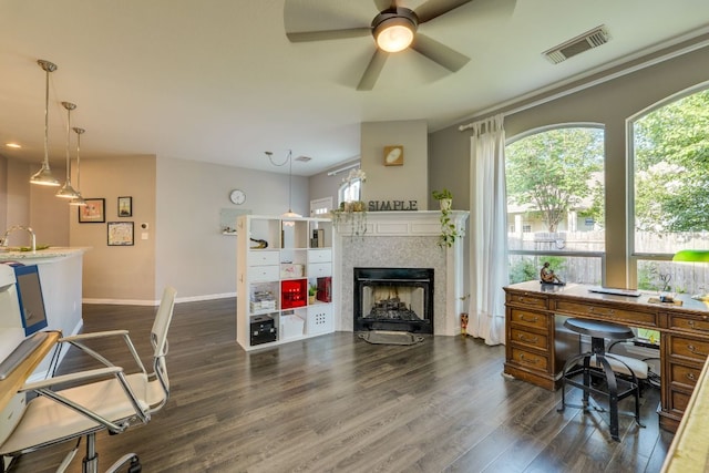 745 Bent Wood Pl, Round Rock, TX 78665 - office area featuring dark wood-type flooring, a fireplace, baseboards, a ceiling fan, and a sink