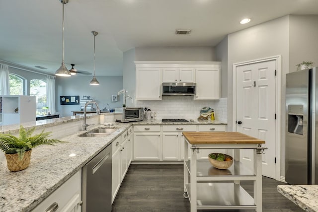 745 Bent Wood Pl, Round Rock, TX 78665 - kitchen featuring appliances with stainless steel finishes, a sink, dark wood-style floors, white cabinetry, and light stone countertops