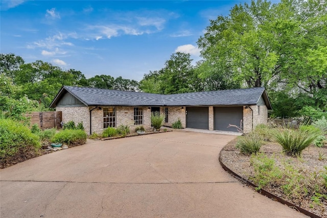 2306 Loyola Ln, Austin, TX 78723 - view of front facade with a garage, concrete driveway, brick siding, and a shingled roof