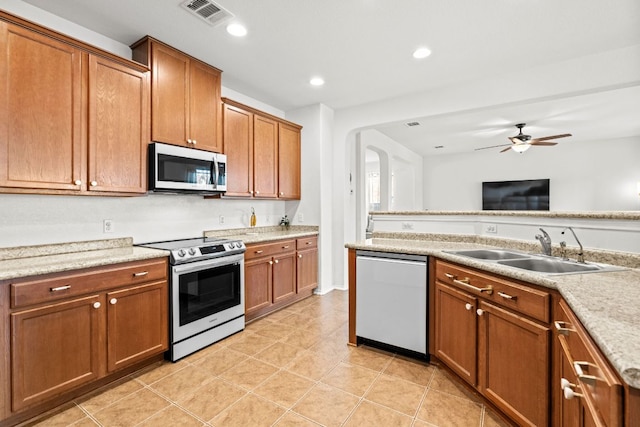 122 Mancos Dr, Georgetown, TX 78626 - kitchen featuring stainless steel appliances, a sink, brown cabinetry, light countertops, and recessed lighting