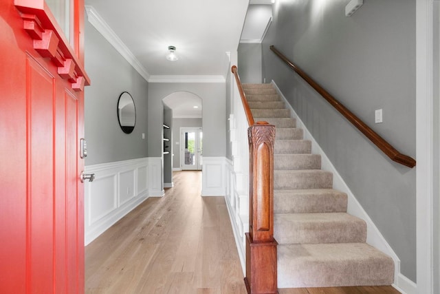 13420 Trail Driver St, Austin, TX 78737 - entrance foyer featuring arched walkways, light wood-style floors, ornamental molding, stairs, and wainscoting