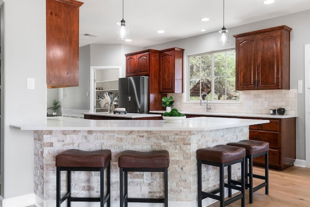 13420 Trail Driver St, Austin, TX 78737 - kitchen featuring freestanding refrigerator, backsplash, a kitchen breakfast bar, and recessed lighting
