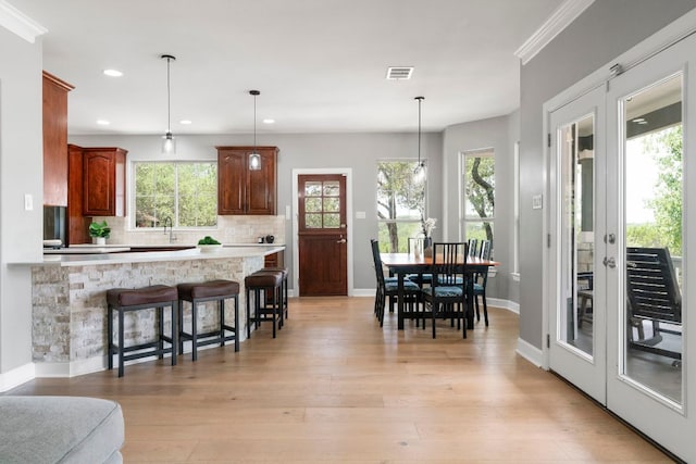 13420 Trail Driver St, Austin, TX 78737 - kitchen featuring a breakfast bar area, recessed lighting, light countertops, tasteful backsplash, and decorative light fixtures