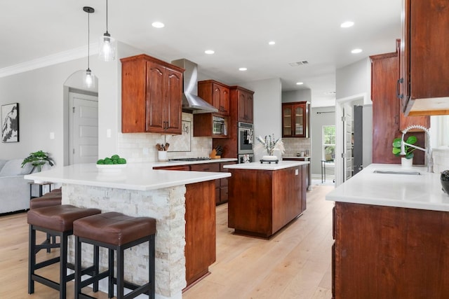 13420 Trail Driver St, Austin, TX 78737 - kitchen with wall chimney exhaust hood, a peninsula, light wood finished floors, decorative backsplash, and a kitchen island