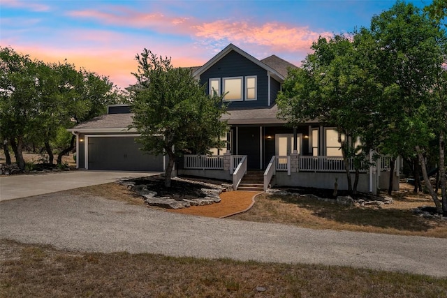 13420 Trail Driver St, Austin, TX 78737 - view of property hidden behind natural elements featuring driveway, covered porch, an attached garage, and roof with shingles