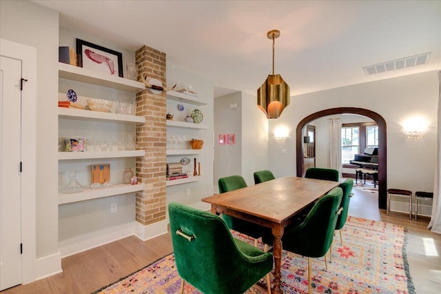 2504 Willow St Unit A, Austin, TX 78702 - dining area featuring arched walkways, wood finished floors, built in features, and baseboards