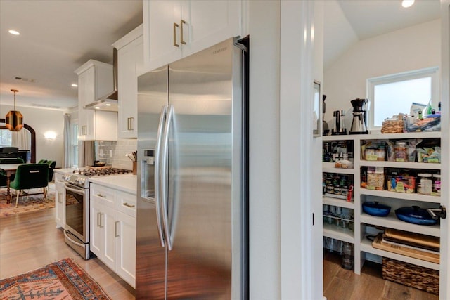 2504 Willow St Unit A, Austin, TX 78702 - kitchen with stainless steel appliances, white cabinetry, tasteful backsplash, light wood-style flooring, and recessed lighting