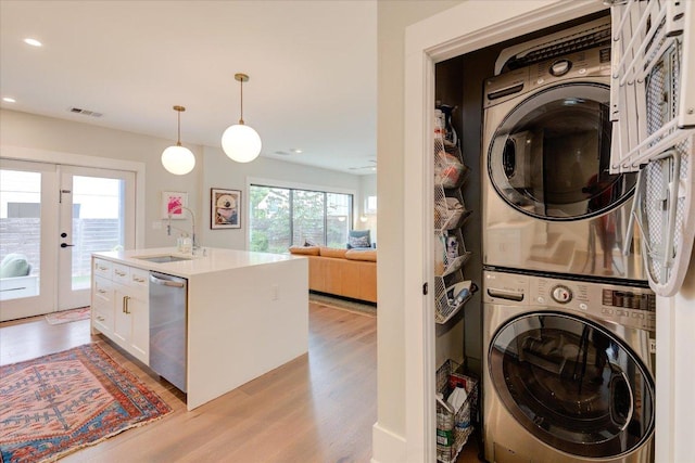 2504 Willow St Unit A, Austin, TX 78702 - laundry room with stacked washer and clothes dryer, light wood-style flooring, recessed lighting, and french doors