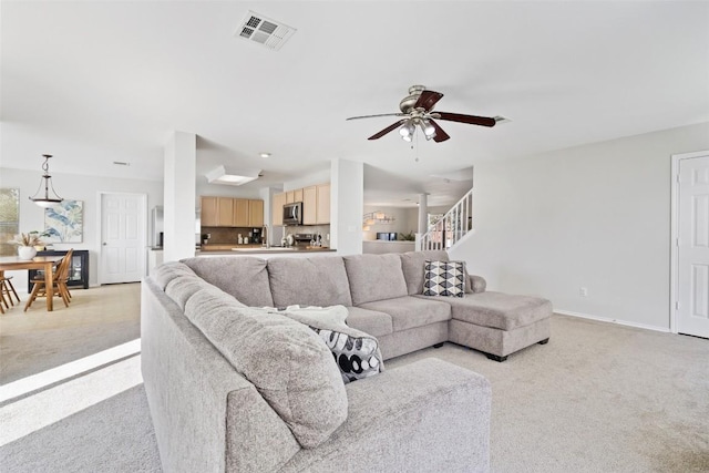 223 Woodlake Dr, Georgetown, TX 78633 - living room with light colored carpet, a ceiling fan, baseboards, and stairs