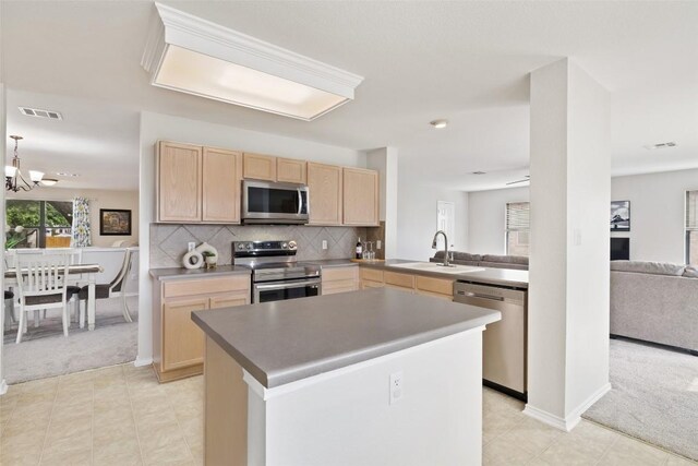 223 Woodlake Dr, Georgetown, TX 78633 - kitchen featuring appliances with stainless steel finishes, light brown cabinetry, a sink, open floor plan, and light carpet