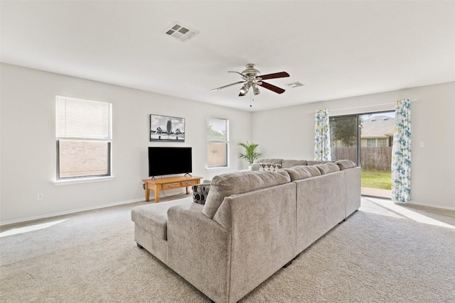 223 Woodlake Dr, Georgetown, TX 78633 - living room featuring plenty of natural light, light colored carpet, a ceiling fan, and baseboards