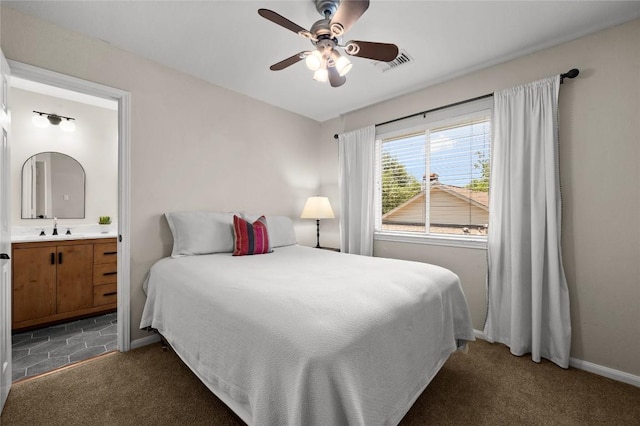 5929 Mesa Verde Cir, Austin, TX 78749 - bedroom featuring a sink, ensuite bath, dark carpet, and baseboards