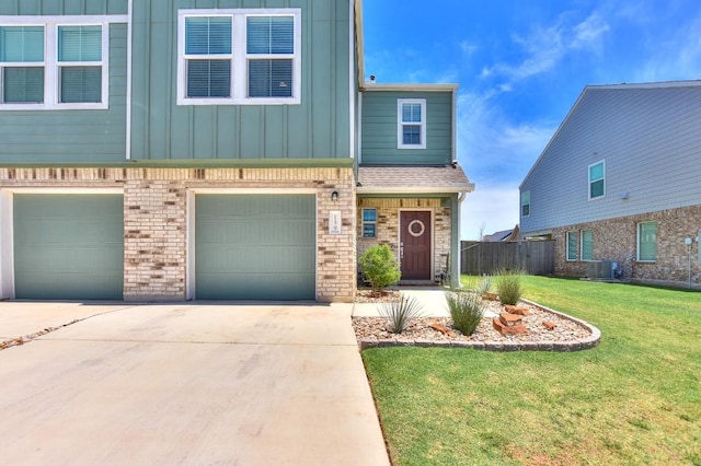 159 Andross Ln, Bastrop, TX 78602 - view of property with driveway, an attached garage, board and batten siding, central air condition unit, and brick siding