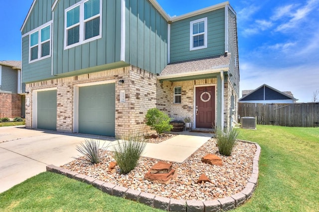 159 Andross Ln, Bastrop, TX 78602 - view of front of home featuring board and batten siding, central AC, concrete driveway, brick siding, and an attached garage