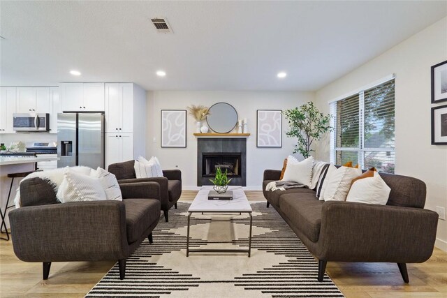 4507 Elana Ct, Austin, TX 78741 - living area featuring light wood-style floors, a fireplace, recessed lighting, and baseboards